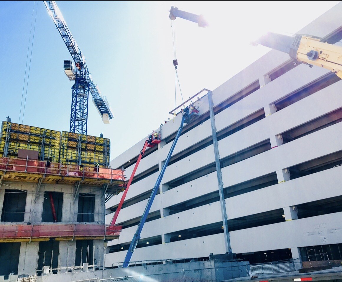 Parking structure panel removal using cranes and elevated work platforms